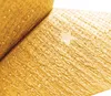 A close-up of a textured golden material with a small star shape embedded in it. Podgląd zdjęcia produktu