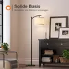 A floor lamp is shown in a living room setting next to a dark wood cabinet. Voir les images du produit