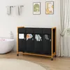 A bathroom setting with a laundry sorter, bathtub, and towels. Anteprima dell’immagine prodotto