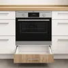 A built-in oven installed in a kitchen cabinet, with a drawer open underneath. Anteprima dell’immagine prodotto