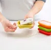 A person is holding a frozen popsicle out of a yellow popsicle mold. There are other colored popsicle molds stacked behind it. Produktbild-Vorschau