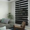 A modern living room with a sofa, chair, and a window with zebra blinds. Voir les images du produit