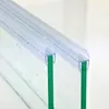 Close-up view of two clear plastic shower door seals attached to green glass panels. Podgląd zdjęcia produktu