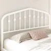 A white metal bed frame headboard with pillows on a bed. Produktbild-Vorschau