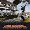 A skateboarder performing a trick on a large pipe in front of a modern building. Náhled obrázku produktu