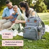 A family is having a picnic in a park with a diaper bag. Náhled obrázku produktu
