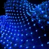 A net of blue lights draped over bushes at night. Produktbild-Vorschau
