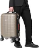 A person in a suit is holding a gold suitcase. Anteprima dell’immagine prodotto