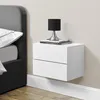 A white floating nightstand with two drawers is mounted on a light gray wall next to a bed. A small black lamp sits on top of the nightstand, which is also holding two books. Anteprima dell’immagine prodotto