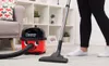 A person is vacuuming a carpeted living room with a Henry vacuum cleaner. Náhled obrázku produktu
