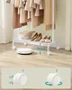 A white rolling garment rack with clothes and shoes on a wooden floor, next to a robot vacuum cleaner. Náhled obrázku produktu