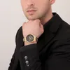 A man wearing a black suit and a gold Maserati chronograph watch. Náhled obrázku produktu