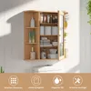 A wooden bathroom cabinet with a mirror, filled with various toiletries and towels, mounted on a white paneled wall. Náhled obrázku produktu