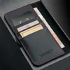 A close-up view of a black leather wallet with red stitching, showing credit cards and a banknote inside. Anteprima dell’immagine prodotto