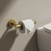 A toilet paper holder with a roll of toilet paper mounted on a wall next to a toilet. Voir les images du produit