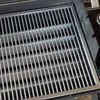 A close-up view of a stainless steel grill grate with multiple horizontal bars. Anteprima dell’immagine prodotto