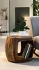 A wooden side table with a plant and books on it, placed next to a chair in a living room. Podgląd zdjęcia produktu