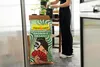 A person is standing in a greenhouse, near a bag of Floragard Professional Growmix Organic. Produktbild-Vorschau