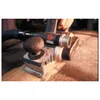A person is using a Bosch electric hand planer on a wooden surface, with a vacuum hose attached. Voir les images du produit