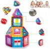 A collection of colorful magnetic building blocks arranged to form a house, with additional blocks and a group of children in the background. Náhled obrázku produktu