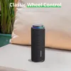 A black Tronsmart T8 outdoor speaker is placed on a light-colored outdoor couch, with a large beige pillow behind it and some greenery to the left. Náhľad obrázku produktu