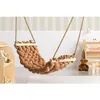 A braided hammock swing in a child's room with shelves and a teddy bear. Podgląd zdjęcia produktu