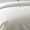 A close-up view of white striped bedding. Produktbild-Vorschau