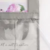 A close-up view of a gray voile roller blind with floral patterns and text. Produktbild-Vorschau