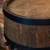 A close-up view of the top and side of a wooden barrel-shaped cabinet with black metal accents. Náhled obrázku produktu