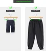 Comparison of baby pants and adult pants on hangers to show adjustable width. Produktbild-Vorschau