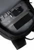 Close-up view of the interior of a black backpack, showing a smartphone and a charging cable in a zippered pocket. Produktbild-Vorschau