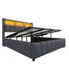 A bed frame with its storage mechanism open, showing the internal storage space and the mattress support. Produktbild-Vorschau