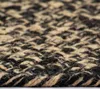 A close-up, detailed view of a woven rug with black and natural jute fibers. Náhľad obrázku produktu