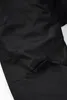 A close-up view of a black outdoor pant with a velcro closure pocket. Produktbild-Vorschau