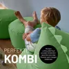 A young boy is sitting on a green beanbag chair, looking away from the camera. There are other green beanbag chairs in the background. Anteprima dell’immagine prodotto