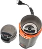 An open coffee grinder with its lid off, showing the blades inside. The grinder has a black and orange body. Náhled obrázku produktu