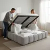A couple is lifting the mattress of a bed to reveal storage space underneath. Náhľad obrázku produktu