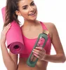 A woman is holding a yoga mat and a water bottle. Voir les images du produit