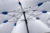 Close-up view of the underside of an open beach umbrella, showing its internal structure and fabric. Voir les images du produit