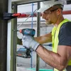 A construction worker is using a Bosch drill to install a window frame. Produktbild-Vorschau