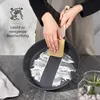A person is cleaning a frying pan with a sponge, showing the non-stick coating. Podgląd zdjęcia produktu