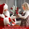 Santa Claus is giving a small Christmas tree decoration to a young girl. Produktbild-Vorschau