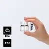 A hand is holding a small glass jar, with dimensions and weight indicated by text overlays and icons. Podgląd zdjęcia produktu