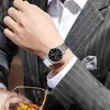 A person wearing a suit and watch, with a glass of whiskey in the foreground. Produktbild-Vorschau