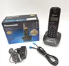 A Panasonic cordless phone and its accessories are displayed on a white background, along with its packaging. Podgląd zdjęcia produktu