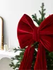 A close-up of a large red velvet bow on a Christmas tree. Podgląd zdjęcia produktu