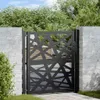 A black metal garden gate with a geometric design is installed between two white brick pillars, with greenery and a wooden fence visible in the background. Anteprima dell’immagine prodotto