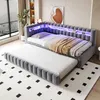 A modern bedroom with a grey upholstered daybed and pull-out trundle bed, featuring integrated LED lighting and shelves in the headboard. Náhled obrázku produktu