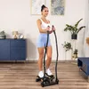 A woman is using a stepper machine in a home setting. Voir les images du produit