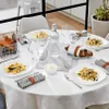 A table set for a meal with plates of gnocchi, bread, and glasses. Voir les images du produit
